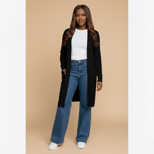 Woman wearing a black cardigan, white shirt, and blue jeans in a living room setting.