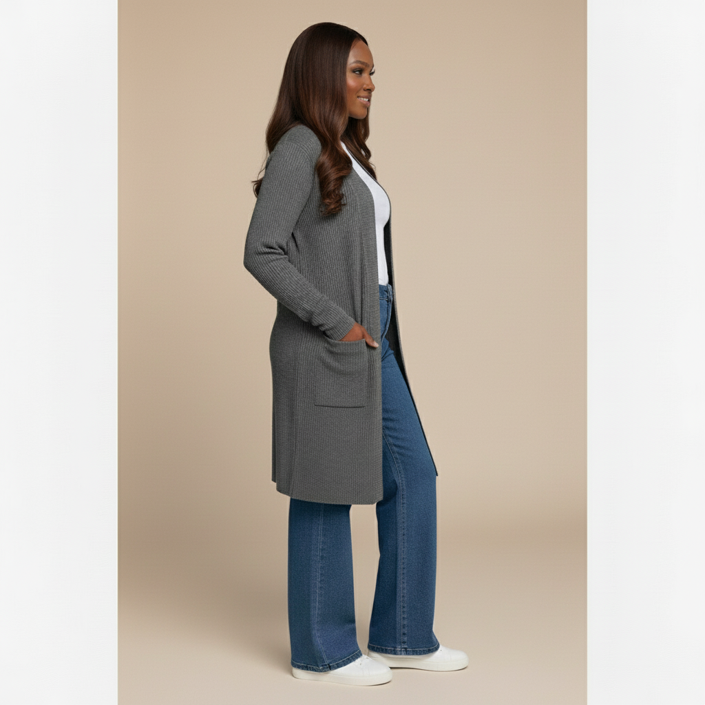 Woman wearing a gray cardigan, white shirt, blue jeans, and white sneakers on a beige background