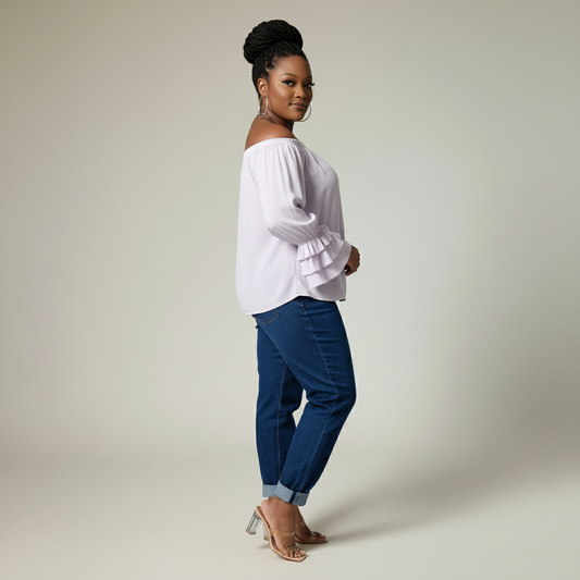 Woman wearing a lilac blouse and blue pants on a plain background